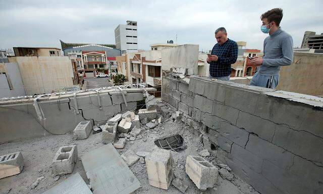 Schadensbesichtigung auf einem Hausdach nach dem Raketenangriff in Erbil.