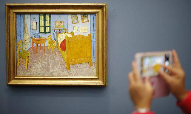 A visitor takes a picture of the painting ´La Chambre de Van Gogh a Arles´ by artist Vincent van Gogh at the Musee d´Orsay in Paris