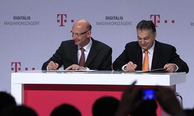 Hungarian PM Orban and Chief Executive of Deutsche Telekom Hottges sign an agreement during a news conference in Budapest