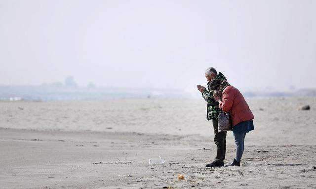 Noch vor 5 Tagen, am 11. Jahrestag der Flutkatastrophe haben Menschen an einem Strand in Fukushima gebetet.