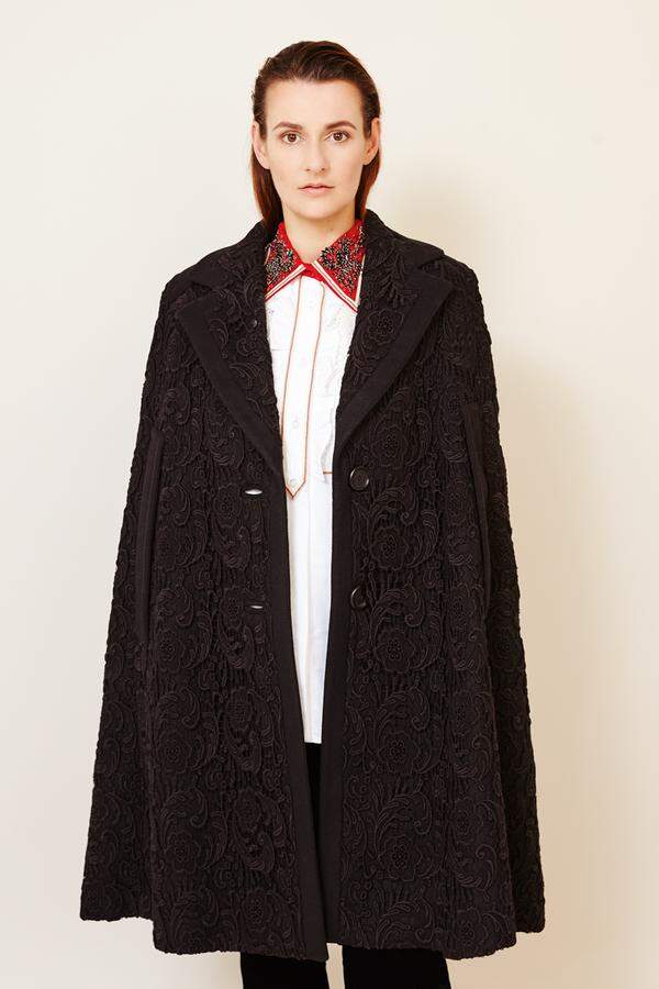 Bluse mit besticktem ­Kragen und schwarzes Cape von Miu Miu, Samthose von Giorgio Armani.