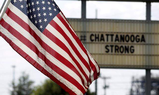 U.S. flag flies alongside a sign in honor of the four Marines killed in Chattanooga, Tennessee