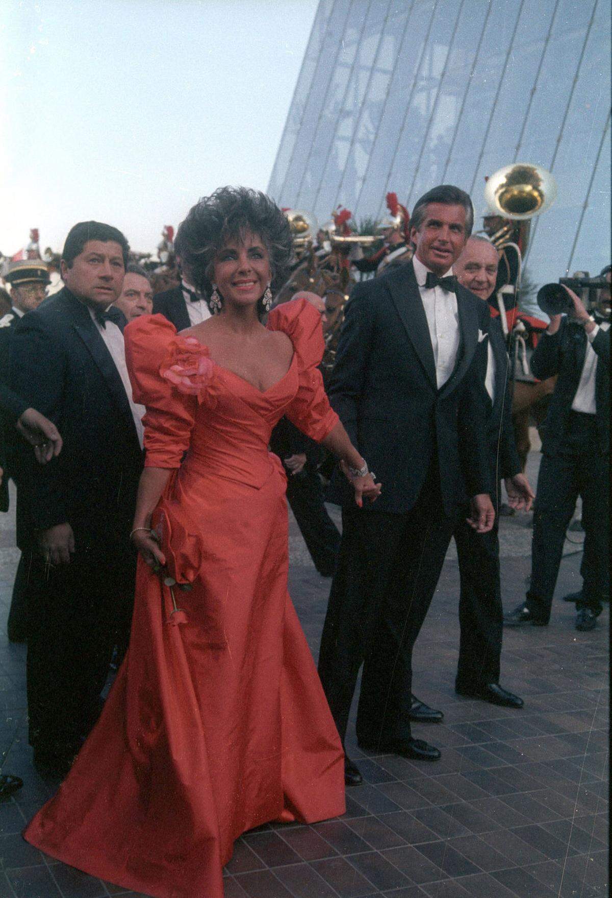 Unzählige Male war auch Filmdiva Elizabeth Taylor in Cannes zugegen. Hier braun gebrannt in einer roten Robe an der Seite von Schauspieler George Hamilton 1987.