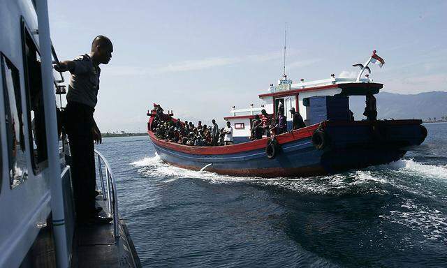 Begleitet durch die Polizei werden Flüchtlingsboote wieder nach Indonesien zurückgeschickt.
