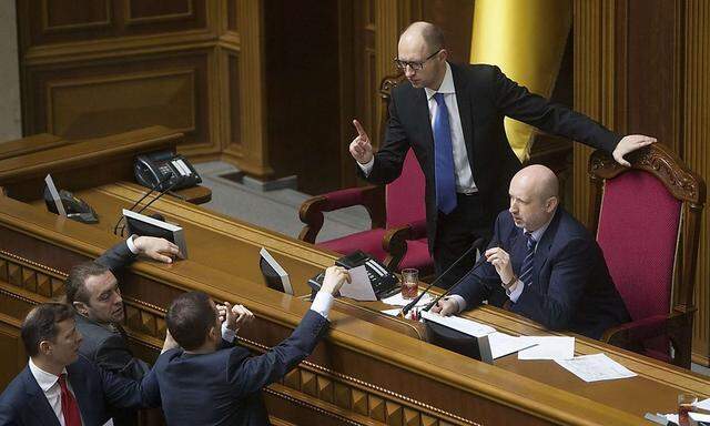 Ukrainian PM Yatseniuk and acting President Turchinov talk to deputies as they attend a parliament session in Kiev