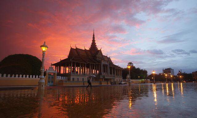 A man walks past the Royal Palace in Phnom Penh