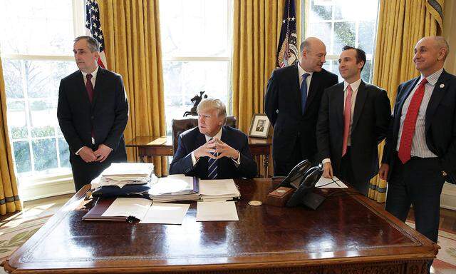 Trump mit Mitarbeitern im Oval Office.