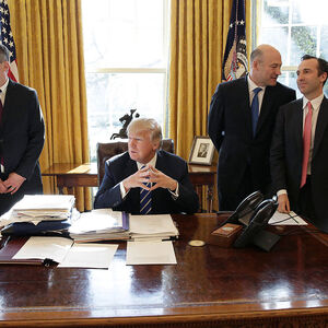 Trump mit Mitarbeitern im Oval Office.