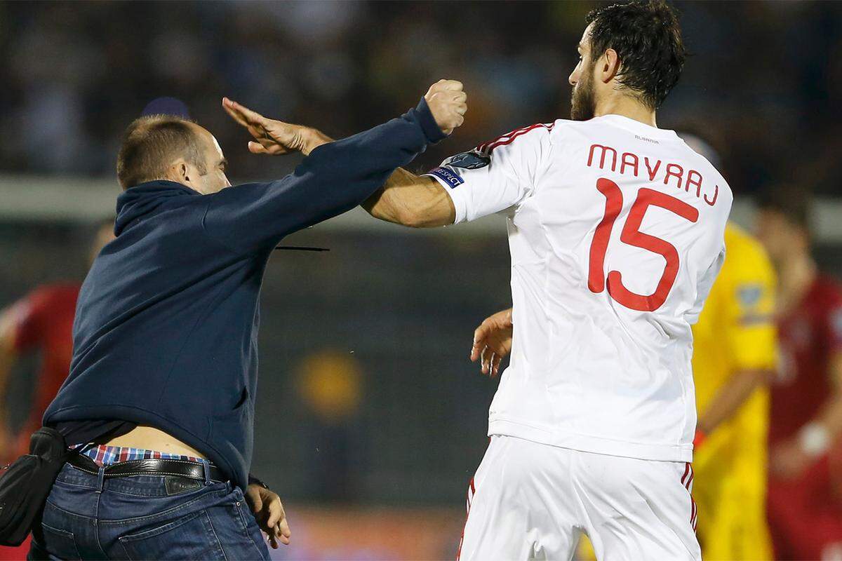 Aufgebrachte serbische Zuschauer stürmen das Feld und attackieren albanische Spieler.
