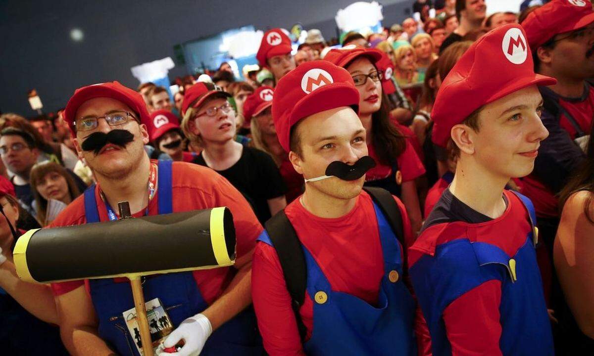 Cosplayers dressed as character 'Mario' celebrate the 30th anniversary of 'Super Mario Bros.' video games developed by Nintendo during the Gamescom 2015 fair in Cologne