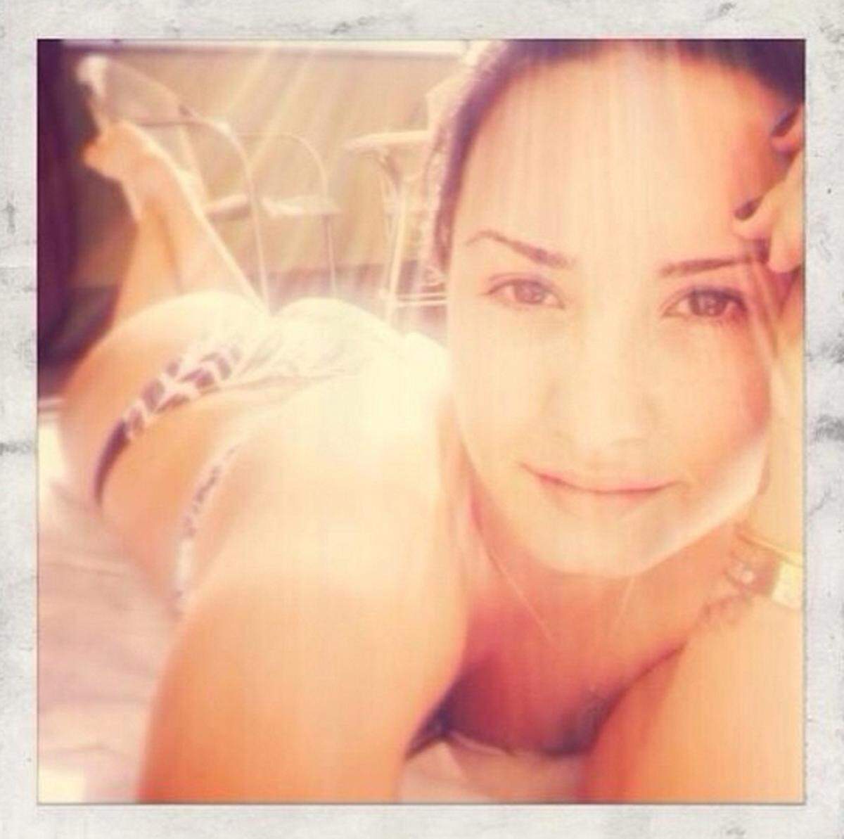 Sängerin Demi Lovato  setzt ihre Kurven besonders geschickt in Szene. Am Bauch liegend sieht man nur ganz leicht im Hintergrund ihren Po.