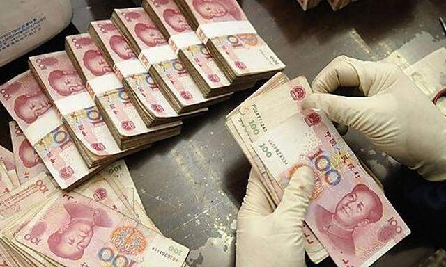 An employee counts yuan banknotes at a Bank of China branch in Changzhi