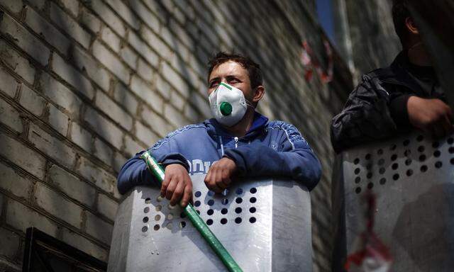 A pro-Russian protester stands at barricades at police headquarters in eastern Ukrainian town of Slaviansk