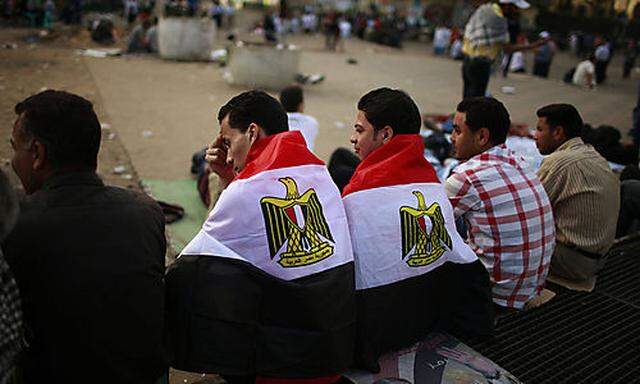 Männer sitzen auf dem Tahrirplatz im Zentrum Kairos