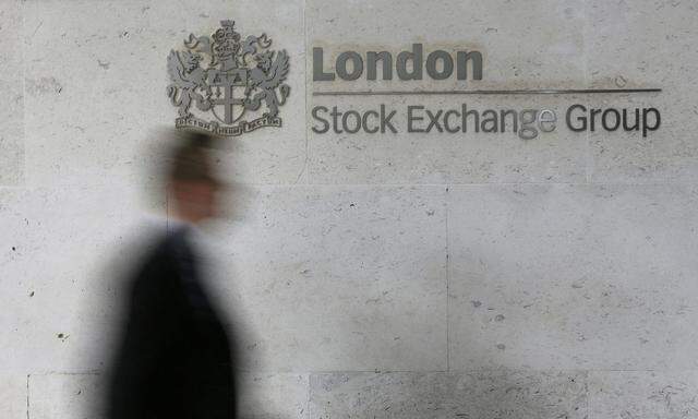 A man walks past the London Stock Exchange in the City of London