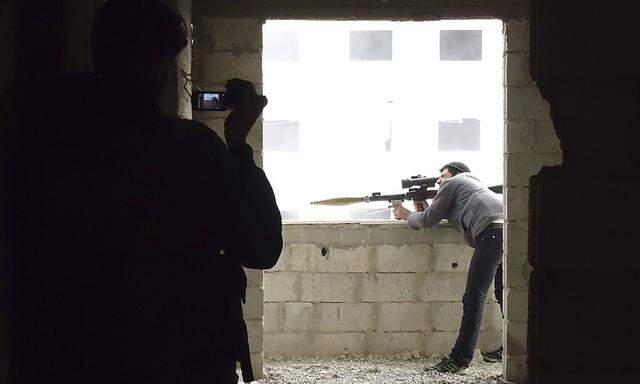 Activist takes a picture of a Free Syrian Army fighter aiming a weapon in Darya near Damascus