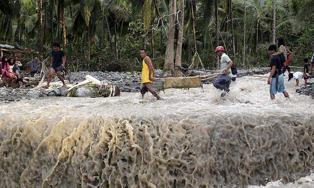 Bewohner tragen eine Leiche durch das überschwemmte Gebiet von New Bataan.