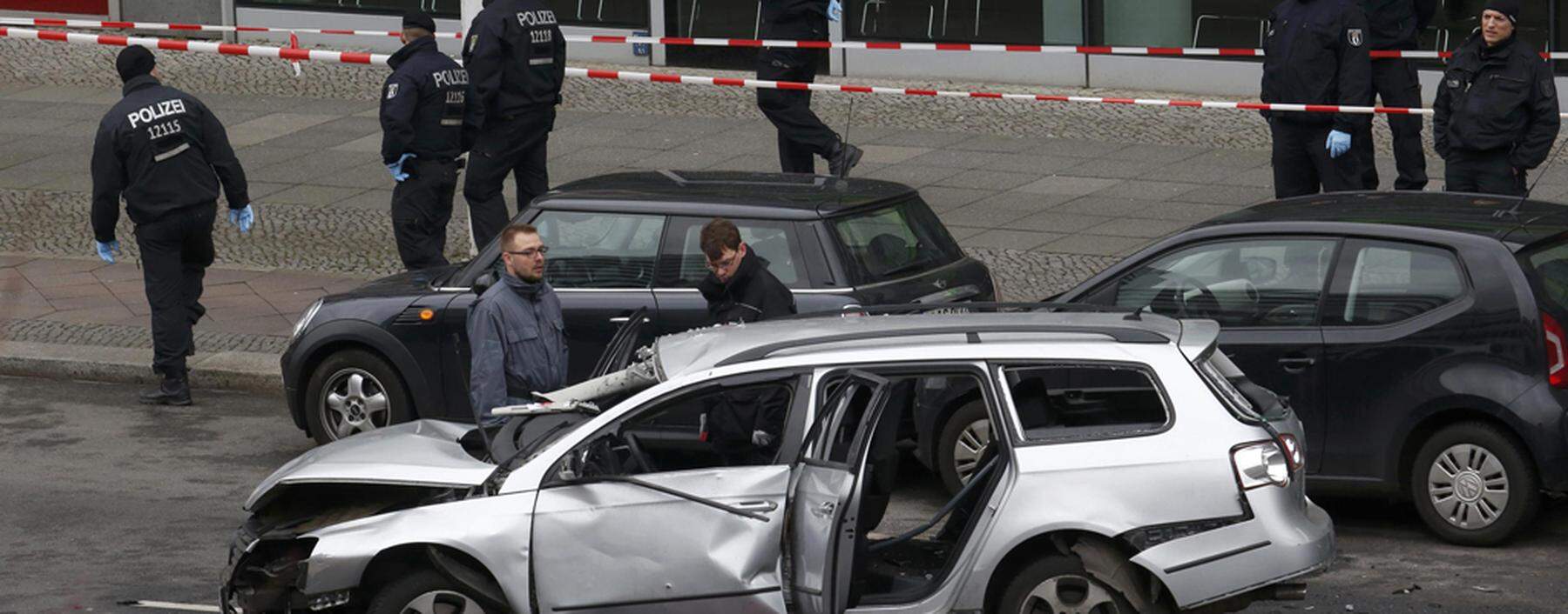 Police inspect a damaged Volkswagen car in the Bismarckstrasse in Berlin