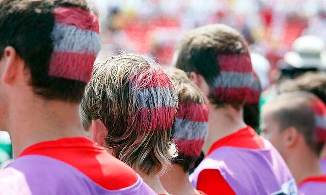 Symbolbild: Österreichische Fußball-Fans mit der Nationalflagge im Haar. 