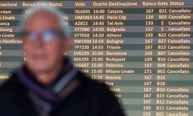 A board displays flights cancellations as a passenger waits for his flight during a strike of Alitalia employees at Rome´s Fiumicino international airport in Rome
