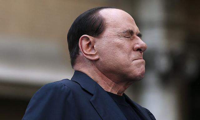 File photo of former Italian PM Silvio Berlusconi closing his eyes in a gesture to supporters during a rally to protest his tax fraud conviction, outside his palace in central Rome