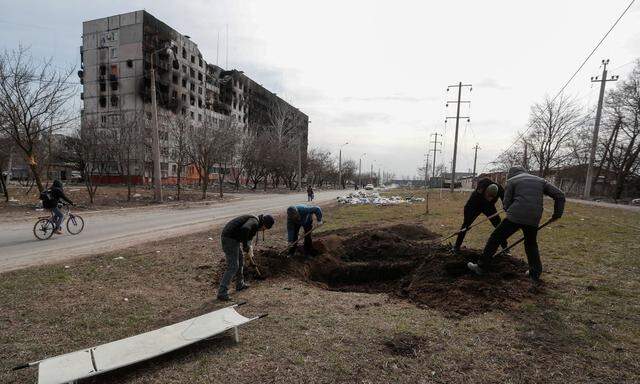 Der Albtraum von Mariupol: Bewohner Mariupols heben in der Hafenstadt Gräber für die Opfer des Kriegs aus.