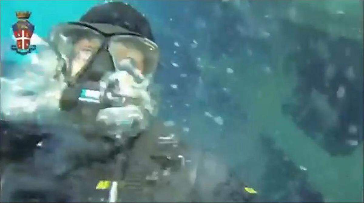 Auf dem Weg ins Geisterschiff: Ein Unterwasser-Spezialist der Carabinieri lässt sich neben der Costa in die Tiefe gleiten.