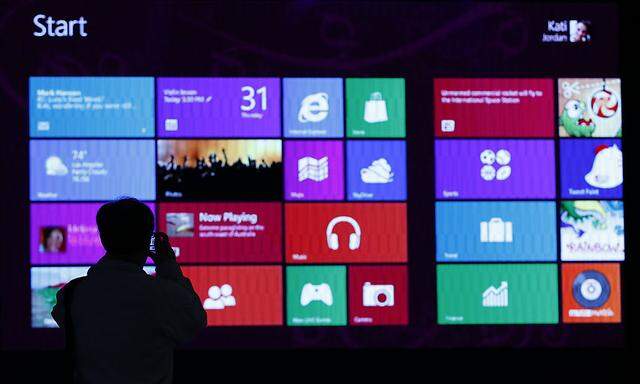 A man takes pictures of a event promoting the debut of Microsoft Corp´s Windows 8 operating system at the Akihabara district