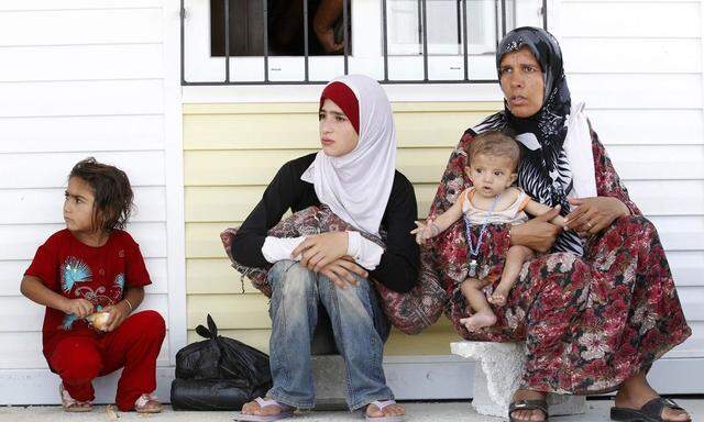 A Syrian refugee woman and her children are seen after fleeing from refugee camp named 'Container City' in Kilis