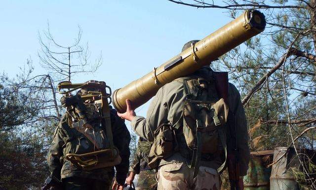 A rebel fighter carries an anti-tank weapon in the Armenian Christian town of Kasab