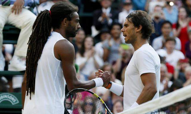 Dustin Brown of Germany shakes hands with Rafael Nadal of Spain after winning their match at the Wimbledon Tennis Championships in London