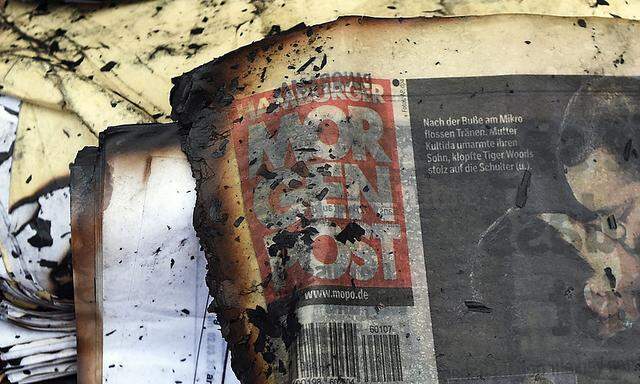 A burned copy of a Hamburger Morgenpost newspaper is pictured among other documents in front of a building of German newspaper Hamburger Morgenpost in Hamburg