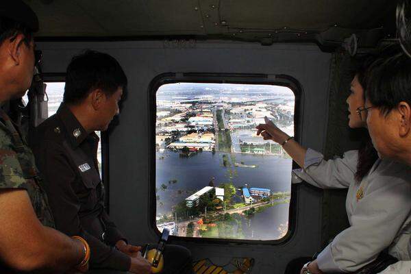 Thailand erlebt seit Wochen die schlimmste Hochwasserkatastrophe seit Jahrzehnten.Bild: Premierministerin Yingluck Shinawatra (2.v.r.) lässt sich Anfang vergangener Woche die überfluteten Gebiete in der Provinz Ayutthaya zeigen.