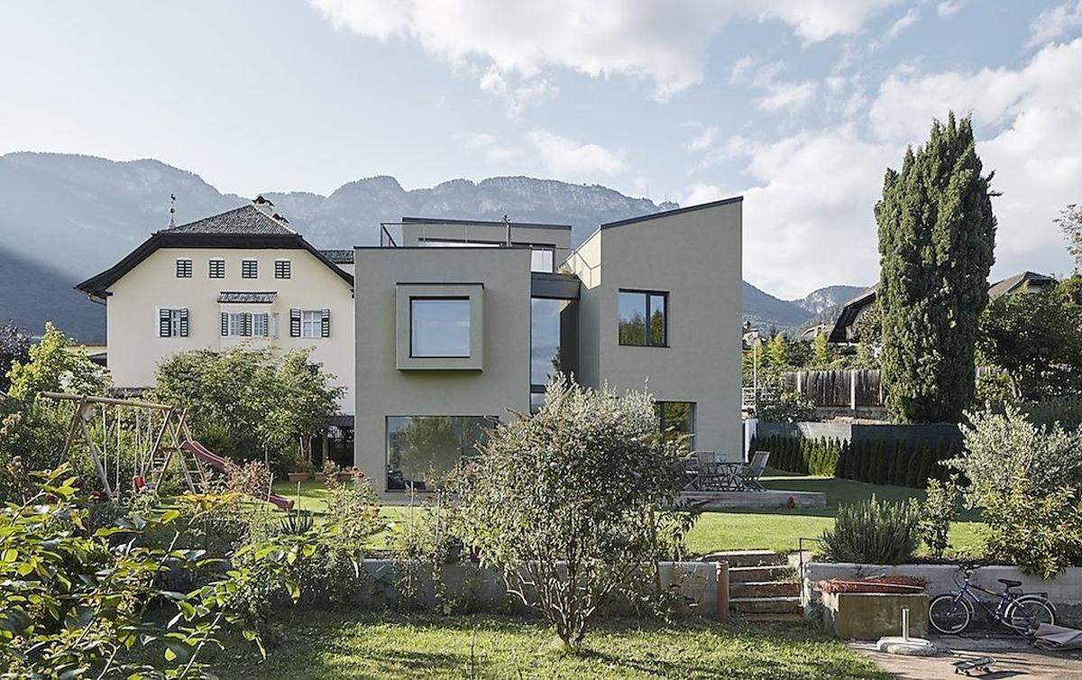 Vier Wohntürme, arrangiert um eine hausinterne Piazza: So konzipierte das Architektenbüro Feld 72 das Südtiroler Einfamilienhaus an der Kalterer Weinstraße. Im Erdgeschoß bilden die Türme einen offenen Platz für Kommunikation und Gemeinschaft, im oberen Geschoß verbindet eine Brücke die einzelnen Häuser und deren Zimmer, die Rückzug und Konzentration ermöglichen. Das hohe Turmhaus führt zur Terrasse.