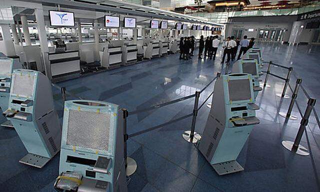 In this photo taken on Aug. 23, 2010, airport staff gather at a ticketing counter, getting ready for 