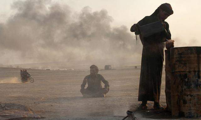 File picture shows a man working at a makeshift oil refinery site in al-Mansoura village in Raqqa