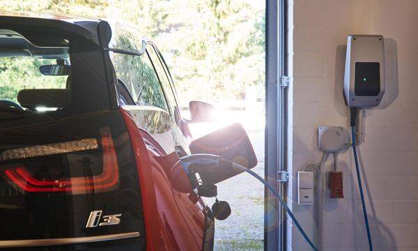 Ein Elektroauto BMW i3 beim Laden an der Wallbox zu Hause in der Garage.