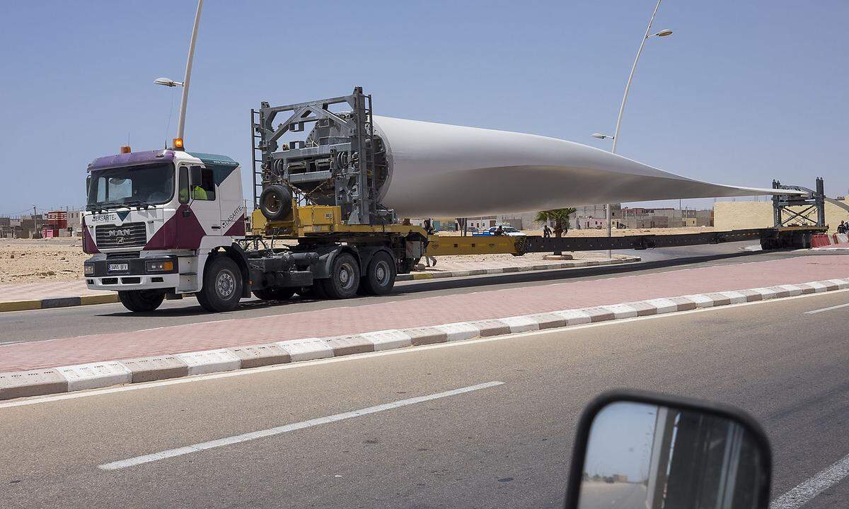 In einigen Gebieten stellen Energieversorger Windparks auf. Die riesigen Flügel werden auf Anhängern angeliefert. Gehört auch zum kargen Straßenbild in der westlichen Sahara. 