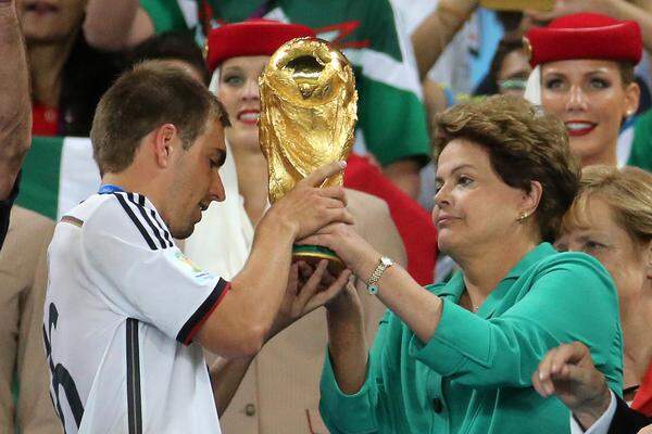 ... Brasiliens Staatspräsidentin Dilma Rousseff dem deutschen Kapitän Philipp Lahm den Pokal für den Fußball-Weltmeister überreichte.