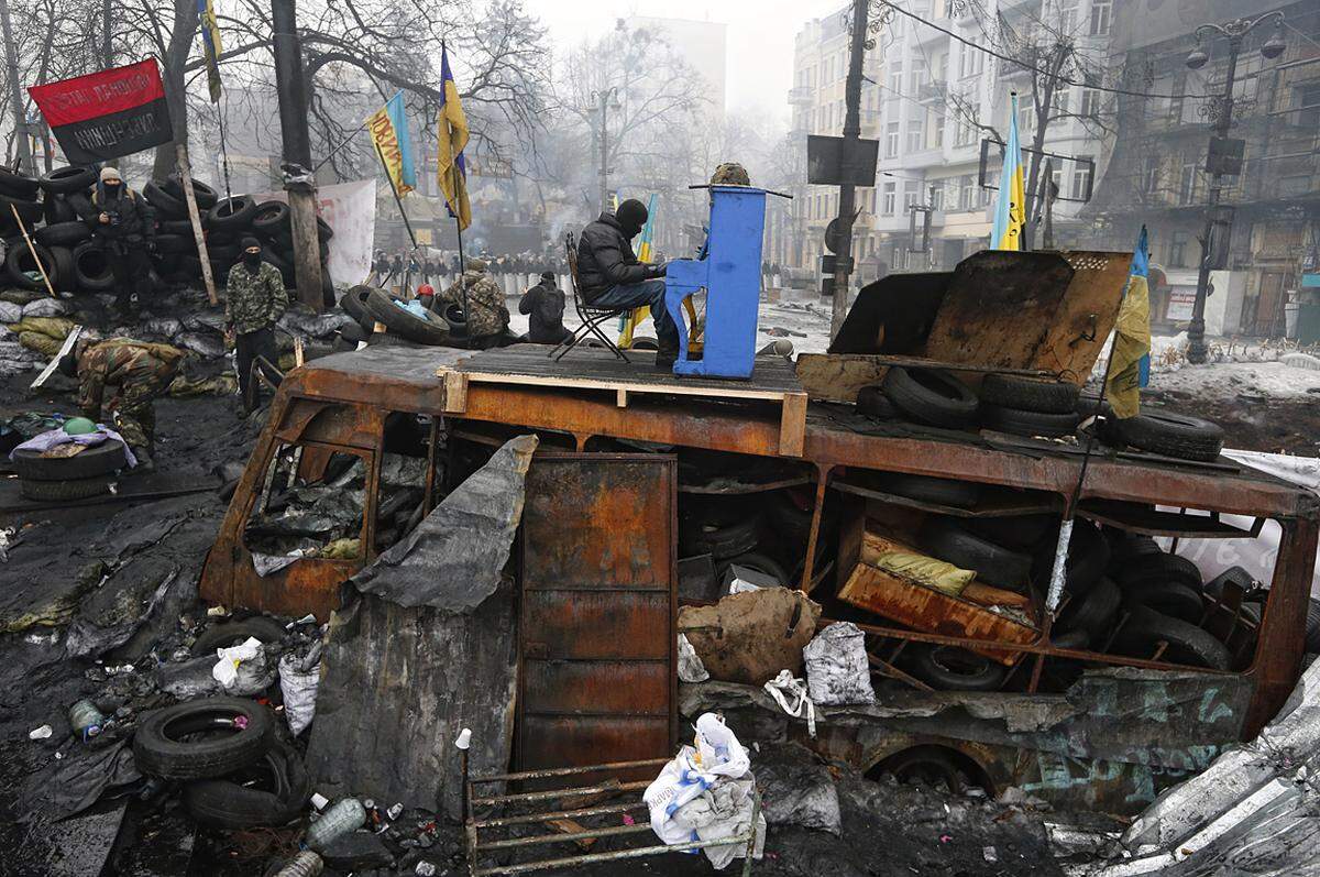 Vladyslav Musiienko, Ukraine: "Maidan"Ein Demonstrant spielt während des Aufstandes auf dem Maidan in Kiew am 10. Februar 2014 vor den Polizeibarrikaden Klavier. Aus der Serie "Ukraine, Kiew, Euromaidan".