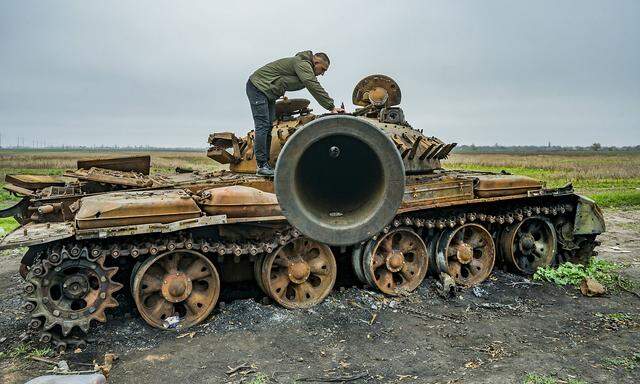 November 12, 2022, Myroliubivka, Kherson, Ukraine: A man checks the turret of russian destroyed tank in the ourskirts o