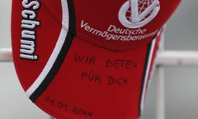 A cap with 'we pray for you' written upon it is placed on a fence outside Michael Schumacher's cart racing track in Kerpen