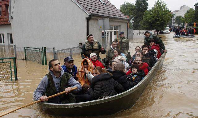 Serbian army soldiers evacuate people in boat in flooded town of Obrenovac