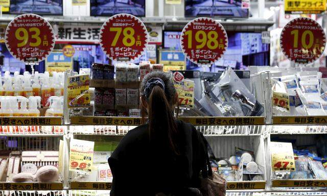 A woman looks at items outside an outlet store at a shopping district in Tokyo