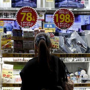 A woman looks at items outside an outlet store at a shopping district in Tokyo