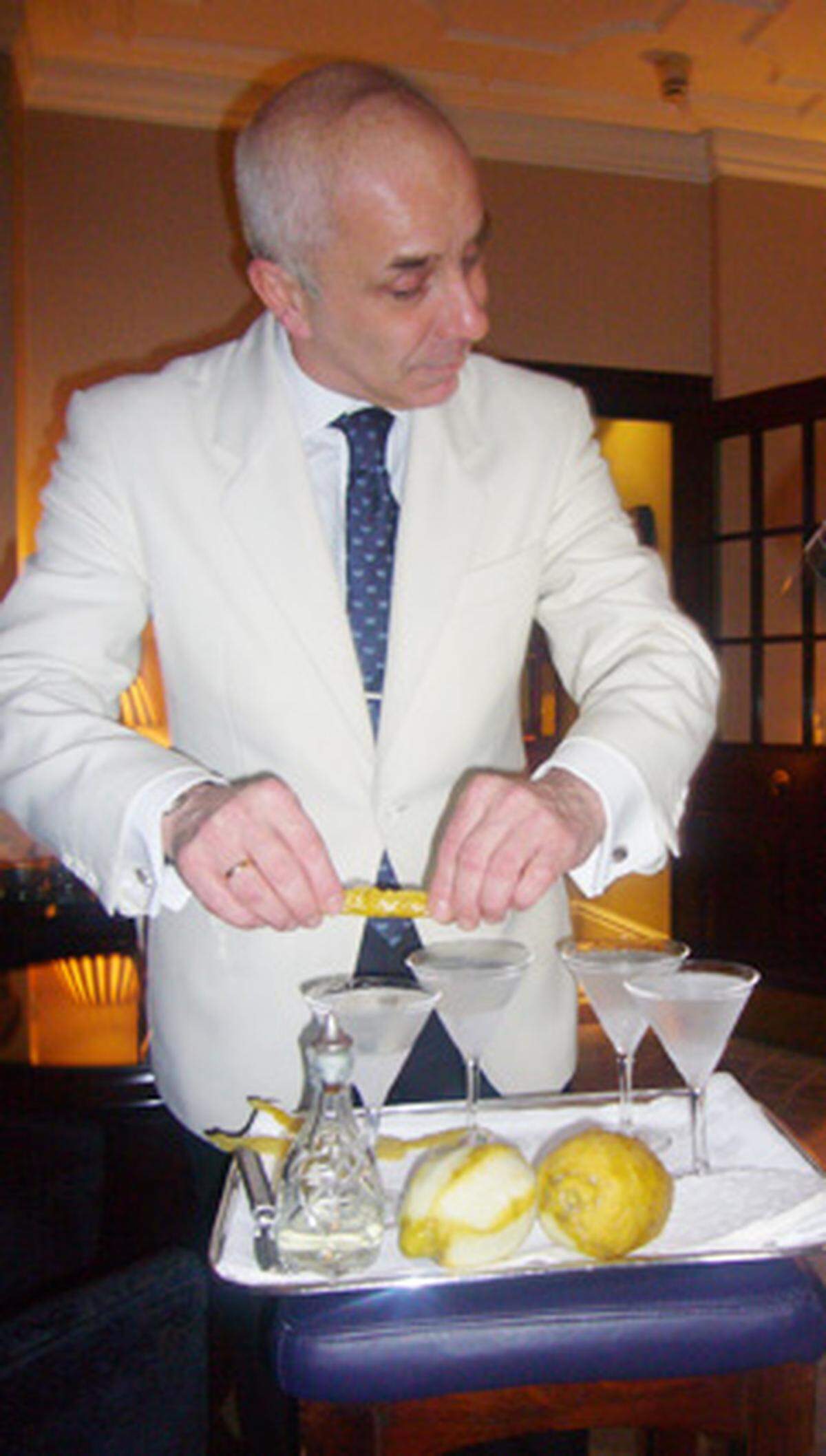 Schritt sieben: Die Zitroneschale über das Cocktailgals geben und ausdrücken. Der Saft der Schale mit den damit verbundenen ätherischen Ölen soll ins volle Martiniglas tropfen.