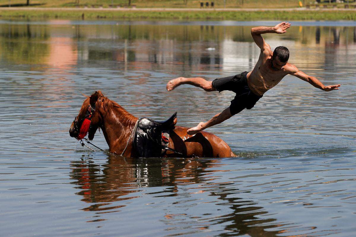 19. Juni. Dem Reiter war wohl ein wenig heiß. Direkt vom Rücken des Pferdes hat er sich in den Fluss Iber geworfen, in Mitrovica, Kosovo.