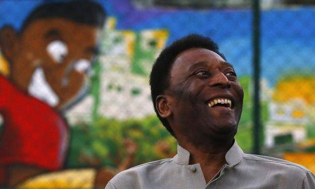 Brazilian soccer legend Pele laughs during the inauguration of a refurbished soccer field at the Mineira slum in Rio de Janeiro