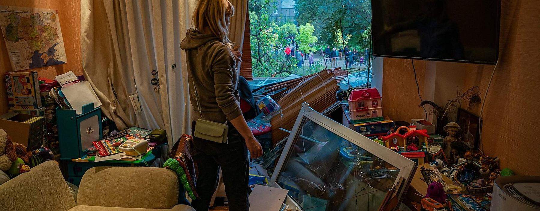 Eine Frau in der Stadt Dnipro betrachtet die Zerstörungen in ihrer Wohnung nach einem russischen Raketenangriff.