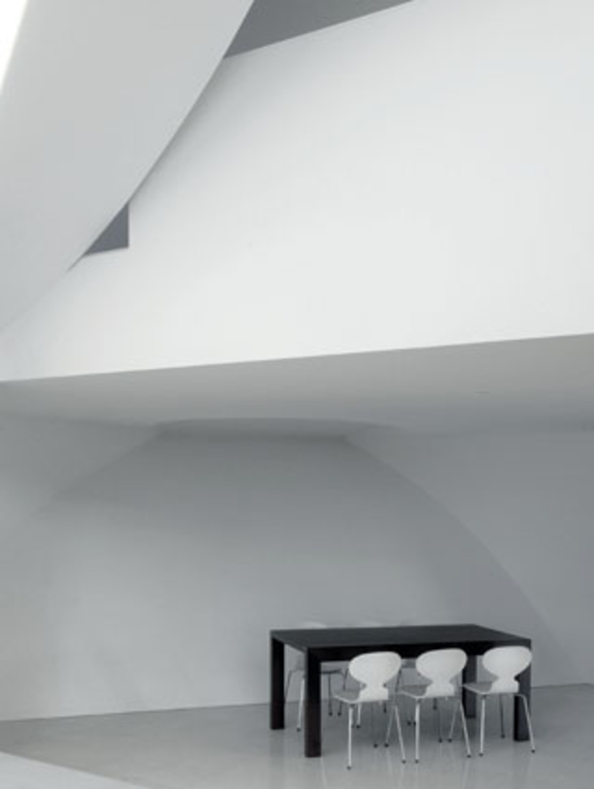 Puristisch geht es hier bei Tisch zu. Wie in einer Vitrine steht der Tisch aus der "Mate"-Linie von Area D6 inmitten der sich biegenden Wände. Eine gewisse Weite entsteht durch das dreidimensionale Gebilde der Wände.